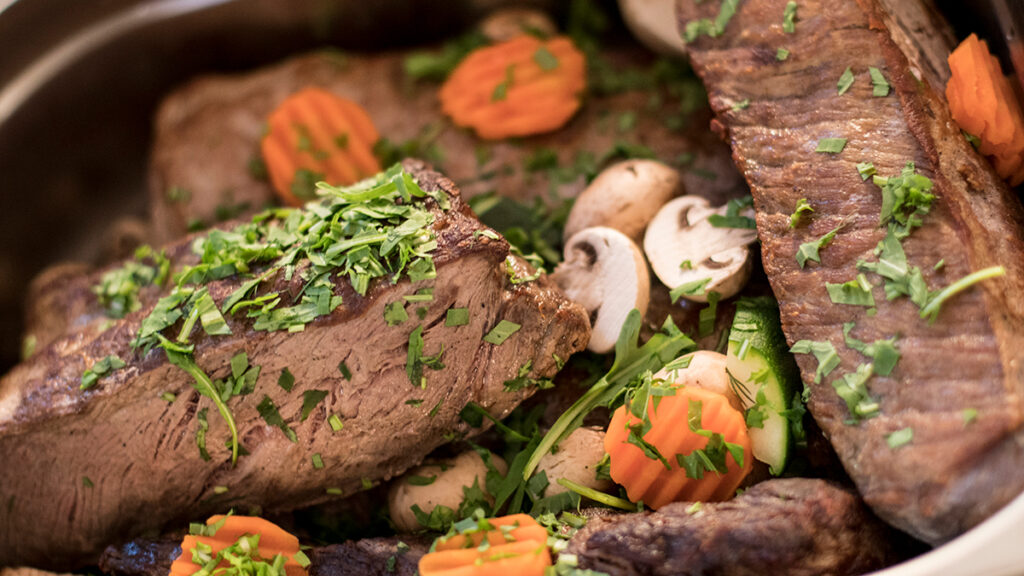 Roastbeef am Buffet garniert mit Gemüse und Kräutern