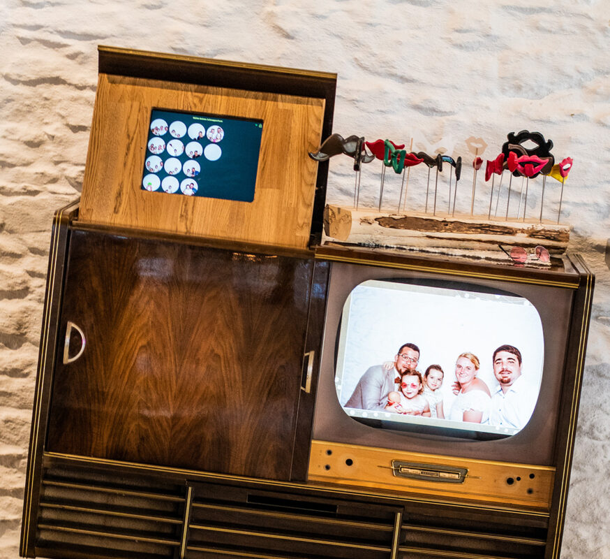 Fotobox-Sharing-Station mit Touchmonitor und Diashow-Monitor, daneben Fotobox-Propx als Verkleidungsuntensilien.