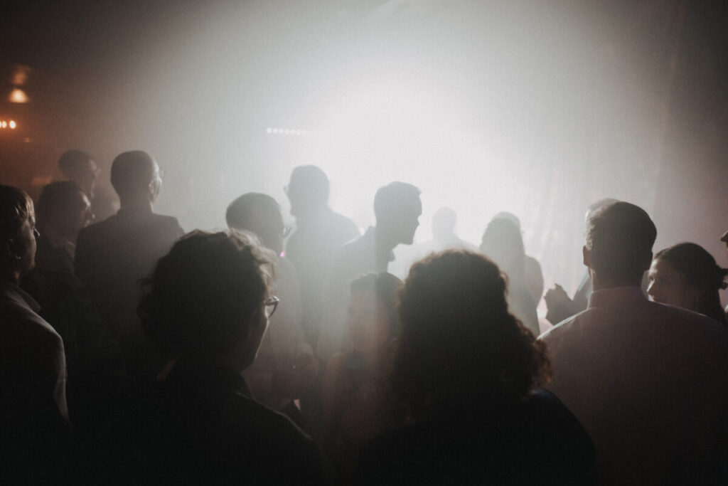 Gäste tanzen auf der Tanzfläche in der Disco, Nebel Lichteffekte.