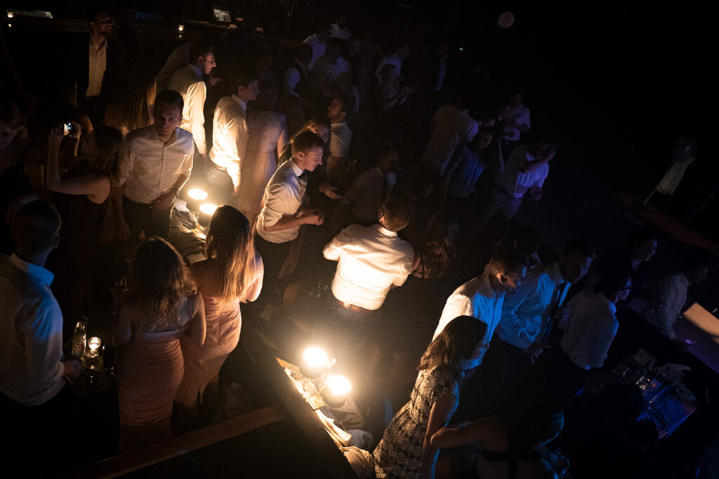 Gäste stehen auf Sitzgruppen im Kino bei einer Party und feiern und Tanzen.