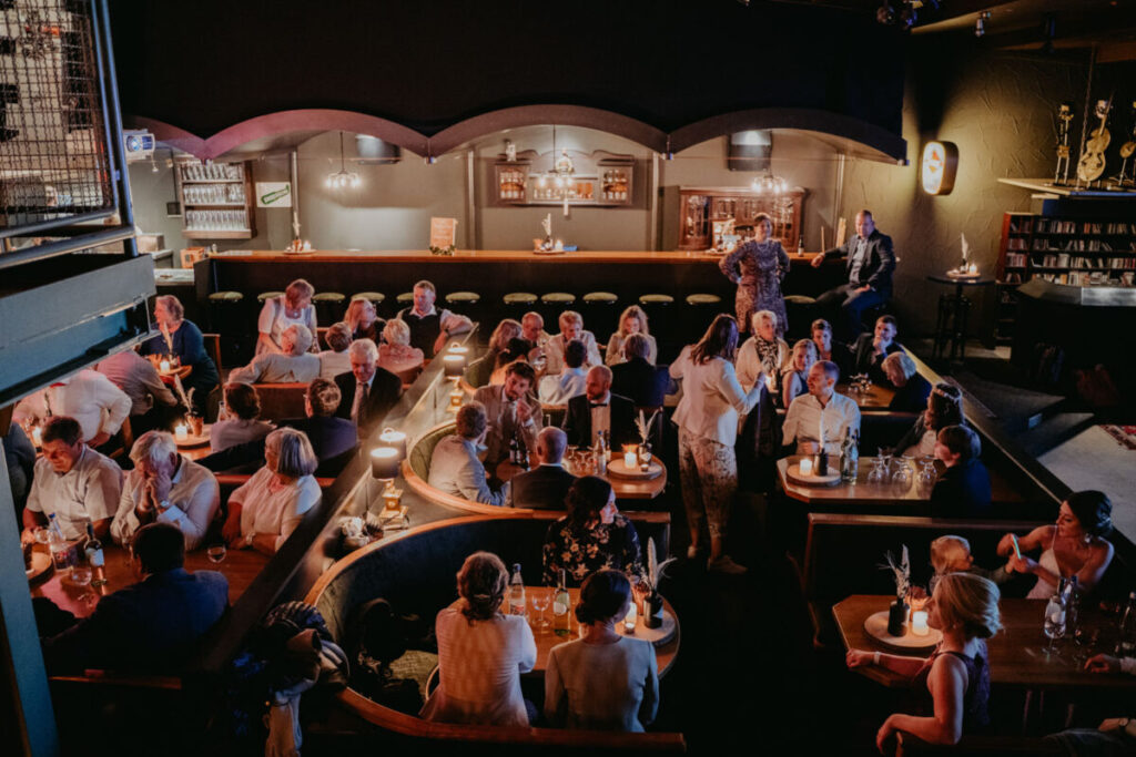 Gäste sitzen in Sitzgruppen im Kino bei einer Brautentführung